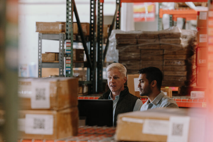 2 shippers looking a computer screen in a warehouse